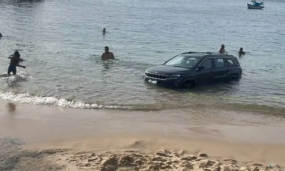 Motorista estaciona em praia e carro é parcialmente submerso após maré subir